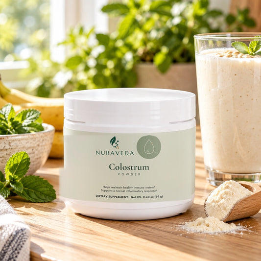 Nuraveda Colostrum Powder with a creamy smoothie and a scoop of powder